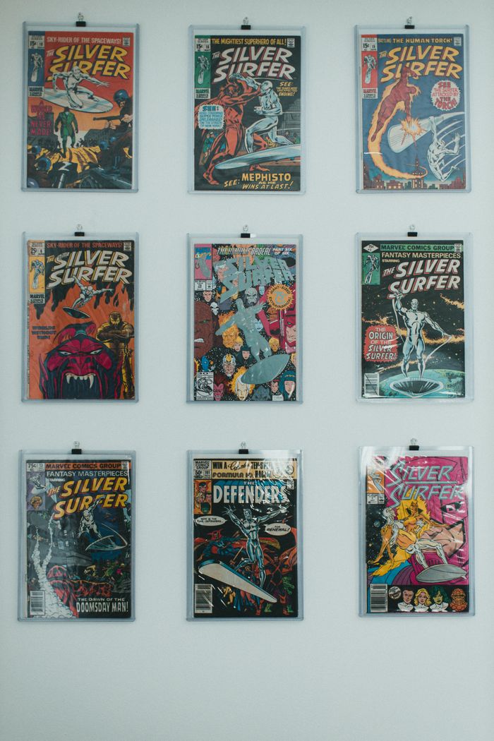 creative-03 A vibrant wall display featuring a collection of classic Silver Surfer comic books in protective sleeves.