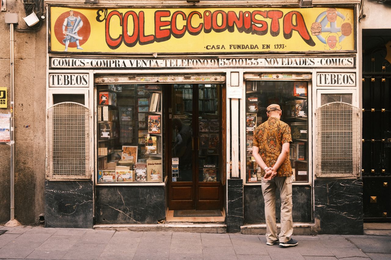 creative-02 A man window shopping outside a vintage comic store in Madrid, Spain.
